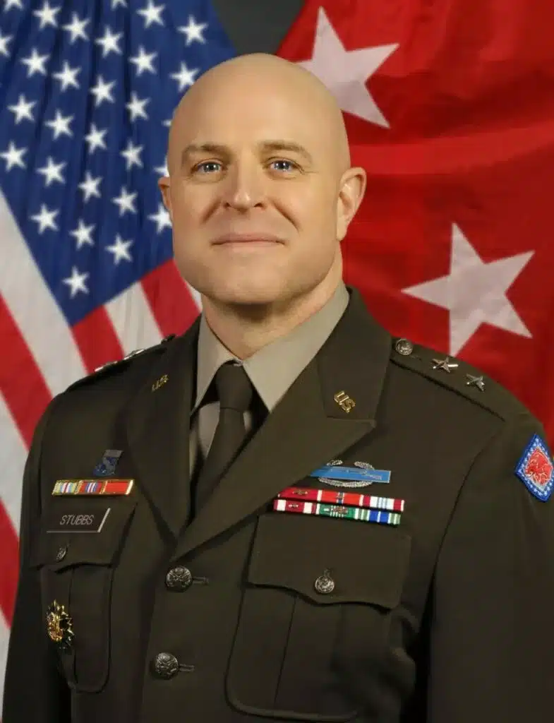 Major General Jonathan Stubbs, Secretary of the Department of Military, posing for his portrait in his decorated Army Service Uniform (ASU) in front of the American flag