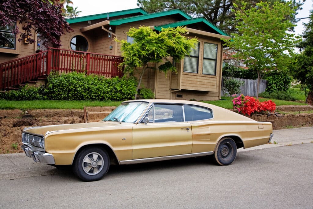 Vintage Dodge Charger car in front of a house.