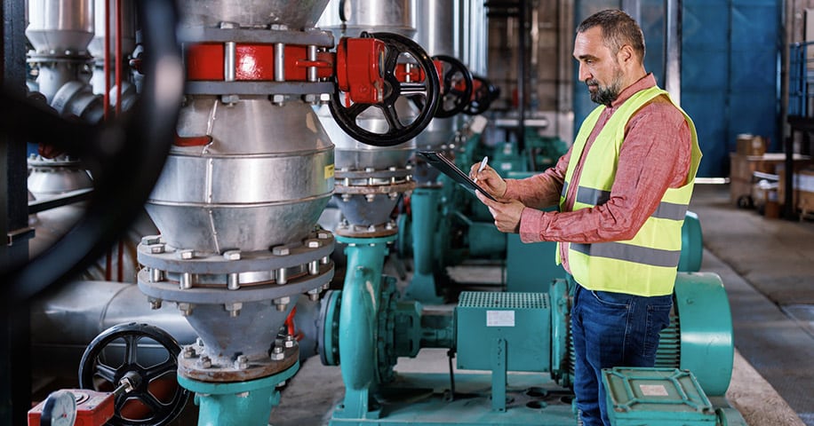 A mature Caucasian male engineer is performing a system check in a heating plant.