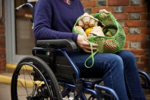 Woman in wheelchair that has been grocery shopping.