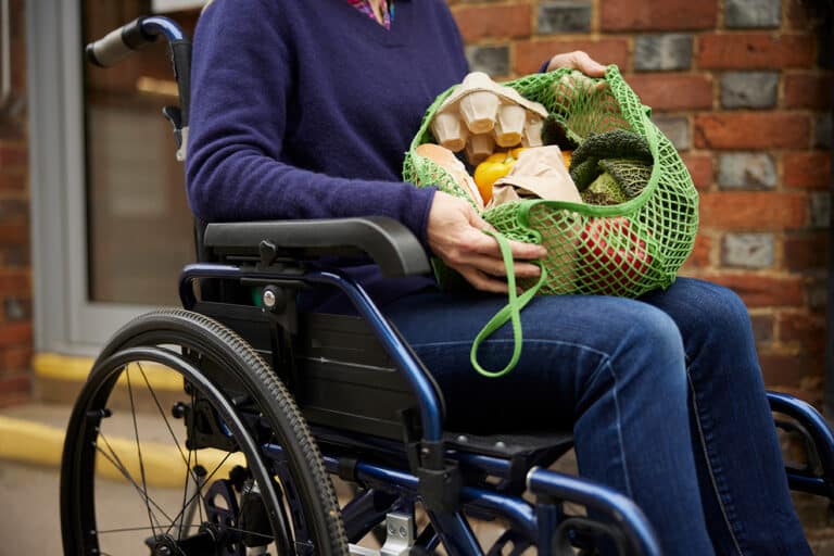 Woman in wheelchair that has been grocery shopping.