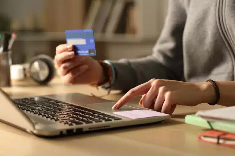 A female signing up for subscription services online with a credit card.